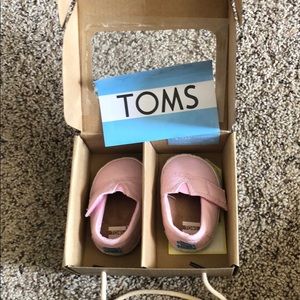 Brand new. Never worn TOMS pink canvas baby shoes